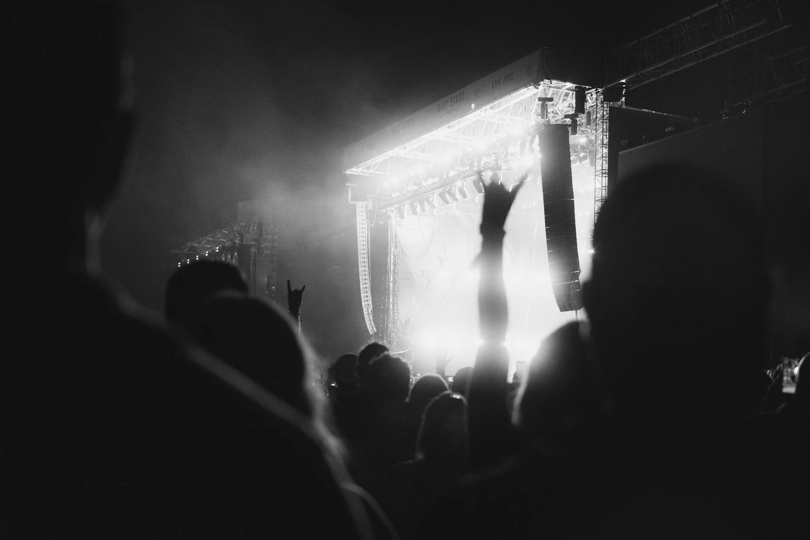 Black and white photograph of a concert crowd with raised hands